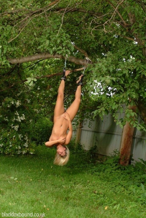 Naked blonde chick is hung upside down from a tree in handcuffs and ball gag | Фото 3