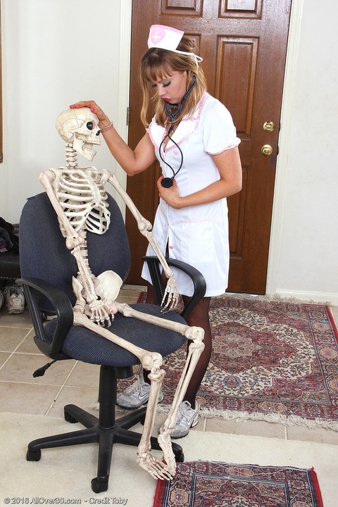 Sexy nurse Christy James peels her white uniform to facesit on a skeleton | Фото 2