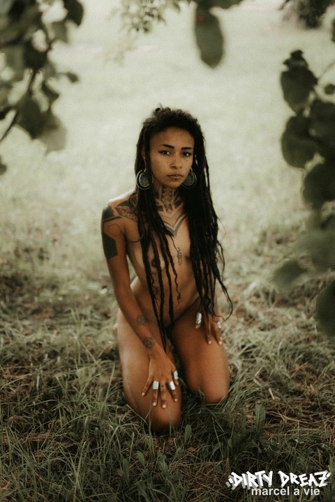 Black girl with long dreads poses totally naked in an abandoned camper