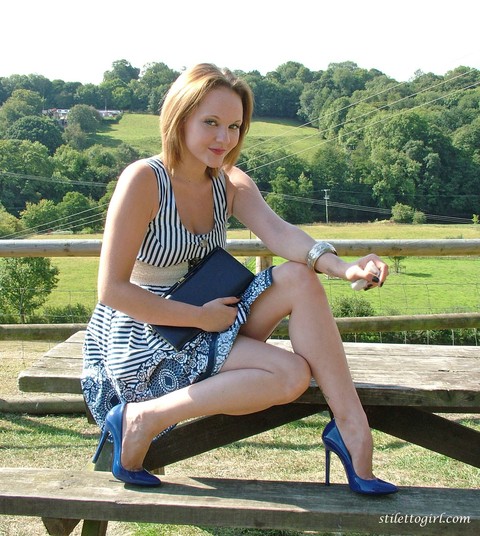 Clothed female shows off her blue stiletto heels on rural picnic table | Фото 2