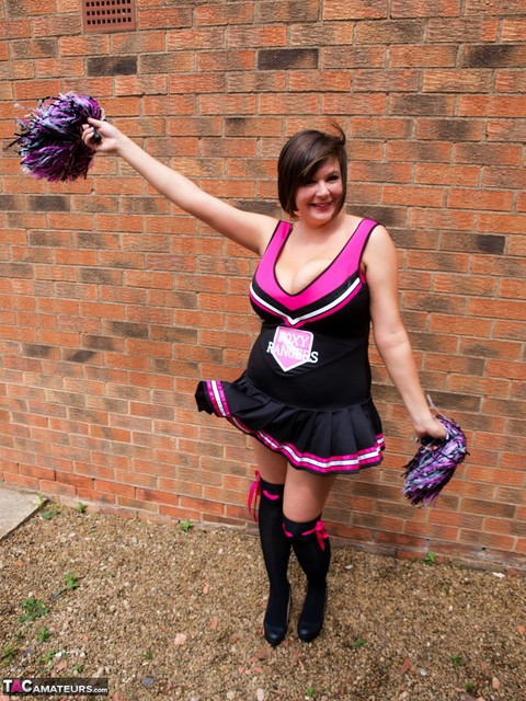 Chubby cheerleader Roxy uncovers her large tits against a brick wall | Фото 2