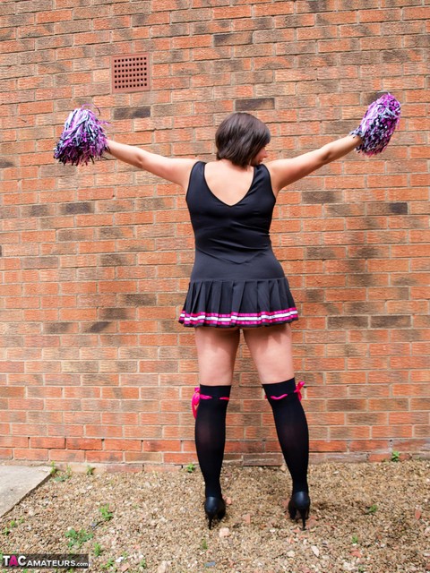 Chubby cheerleader Roxy uncovers her large tits against a brick wall | Фото 4