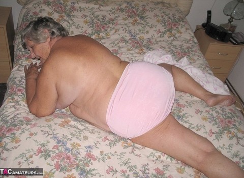 Old woman Grandma Libby grabs her fat roll after getting naked on a bed