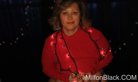 Cute chubby amateur MILF poses in her sexy outfit under Xmas lights