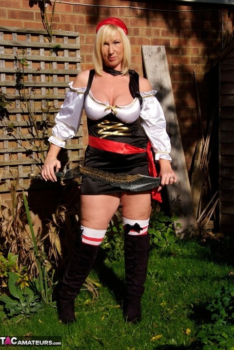 Fat blonde Melody frees her large boobs in a yard while sporting cosplay gear | Фото 1