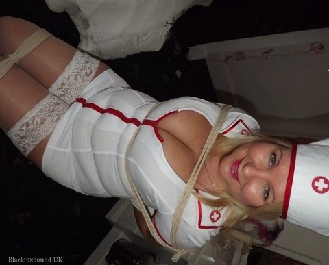 Older blonde with big breasts is tied up in a naughty nurse uniform