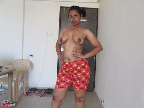 Topless Indian woman begins to pull down her shorts and underwear