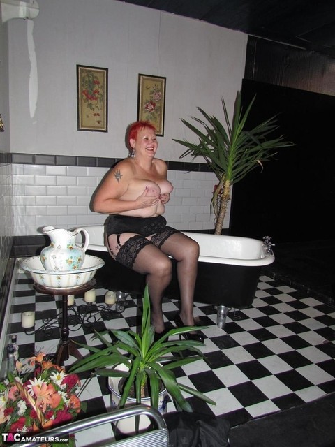 Older redhead Valgasmic Exposed steps into a bathtub while wearing stockings | Фото 13