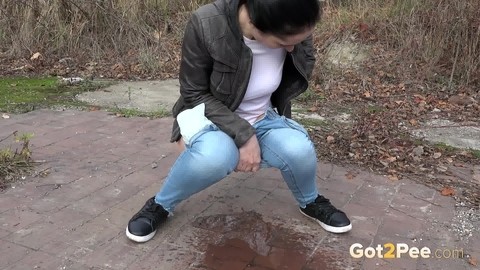 Clothed woman Corin pulls down her jeans for an urgent piss on a vacant lot | Фото 13