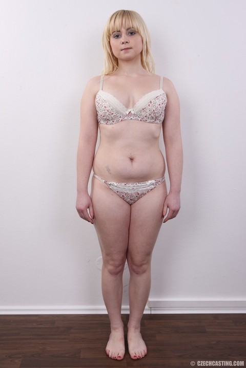 Plump blond girl removes her clothes until she's standing naked against a wall | Фото 6