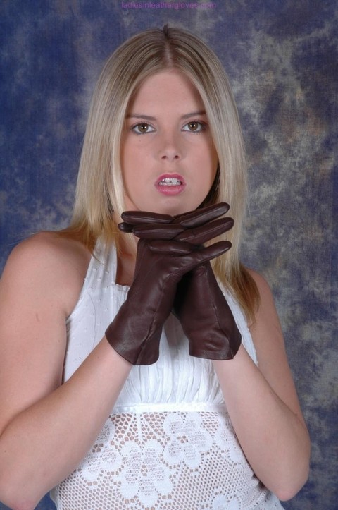 Blonde female pulls on brown leather gloves while wearing a white dress | Фото 13