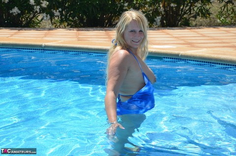 Older blonde Sweet Susi frees her tits and ass from a bathing suit in a pool | Фото 14