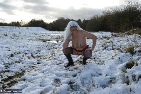 Mature platinum blonde gets naked on snow-covered ground in black boots | Фото 14