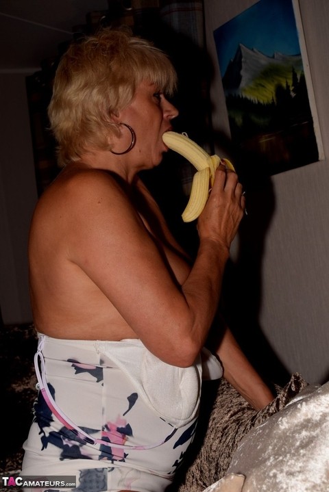 Mature blonde Dimonty exposes her tits and twat while eating a banana | Фото 6