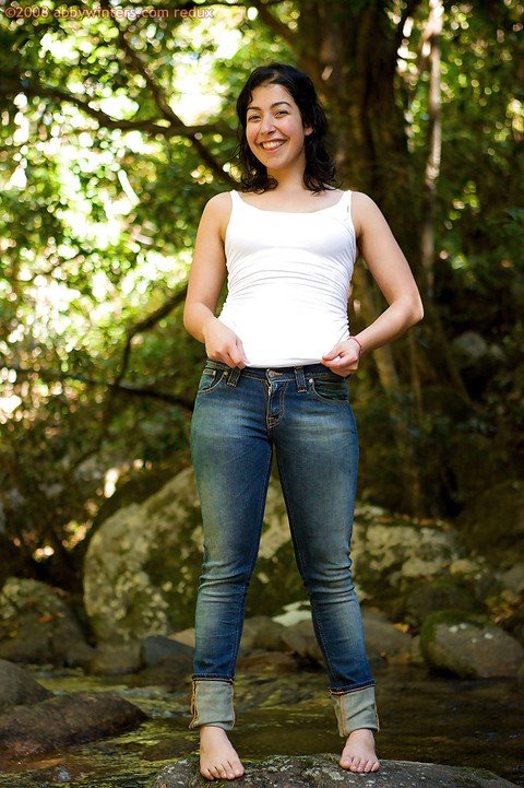 Barefoot solo girl stripping off her blouse and jeans outdoors | Фото 1