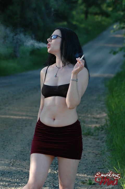 Brunette chick exposes her naked body on gravel road while smoking | Фото 3