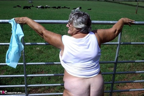 Old British woman Grandma Libby exposes herself next to a field of cattle