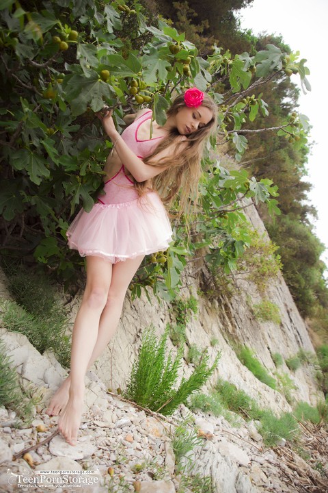 Cute teen Sunna covers her naked pussy in delicate flowers on a rocky shore | Фото 2