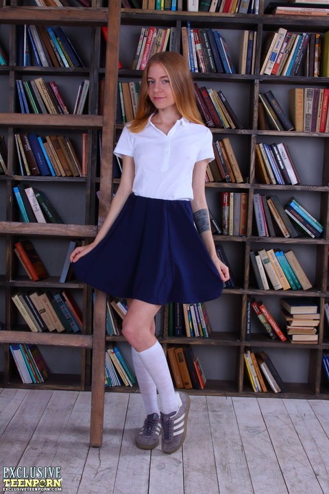 Slim schoolgirl Chloe strips to knee socks in front of book stack | Фото 1