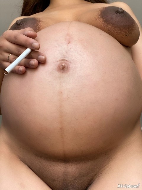 Pregnant smoker Leila teasing nude with her bulging tummy & her dark nipples