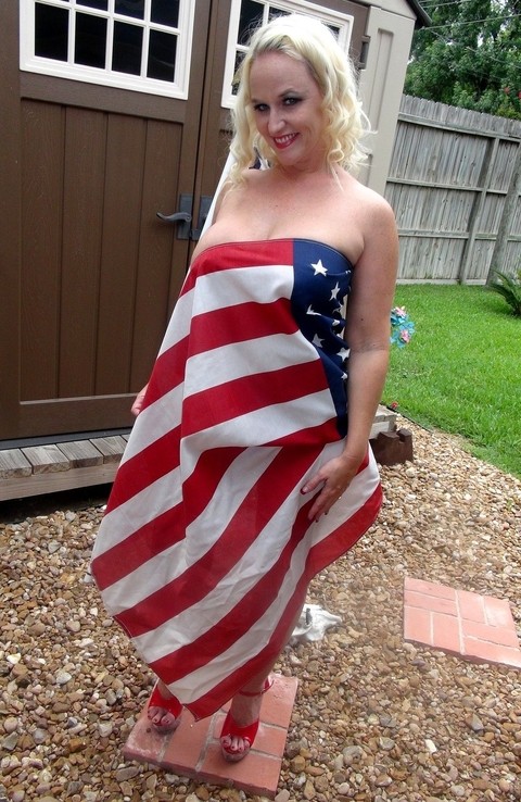 Blond amateur Dee Siren holds a USA flag while showing her big tits in a thong | Фото 5