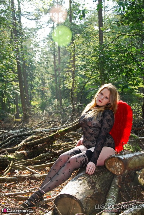 Amateur model poses in lingerie and stockings with angel wings in the woods