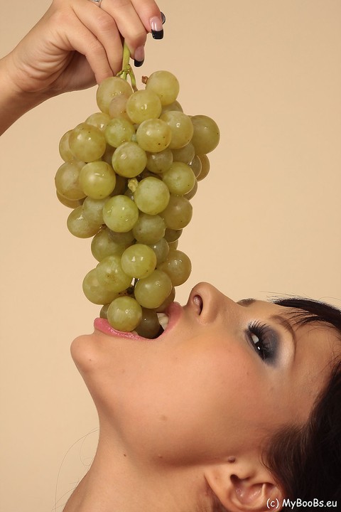 Hot brunette Domino munches on a grape bunch while removing her clothes | Фото 1