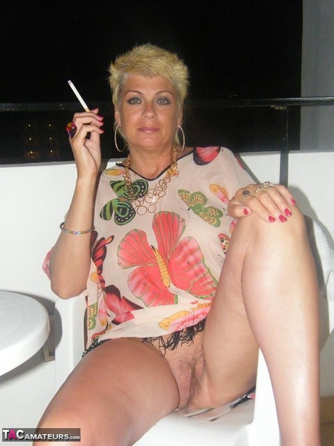 Mature MILF with blonde hair and big tits shows her twat while having a smoke | Фото 19