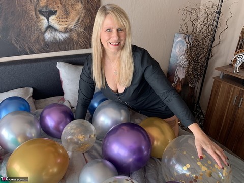 Middle-aged blonde Sweet Susi gets naked on her bed amid balloons | Фото 1