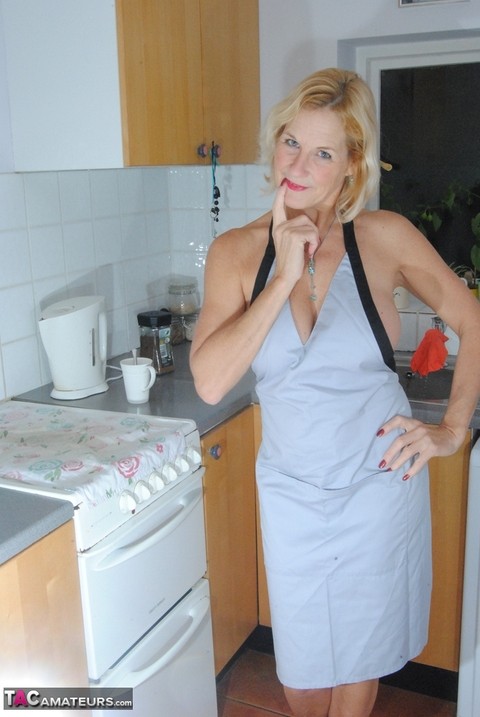 Mature MILF with blonde hair wears only an apron while devouring a banana | Фото 8