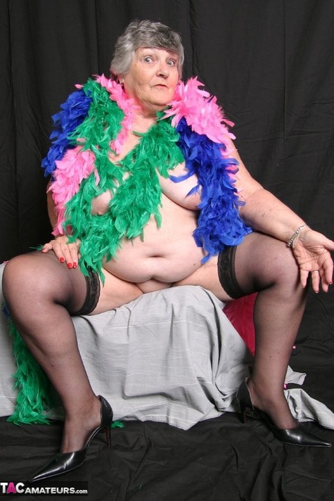 Fat UK amateur Grandma Libby shows her big tits while draped in feather boas