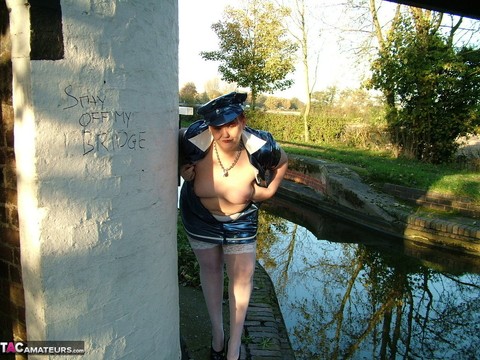 Older redhead Valgasmic Exposed exposes herself by a canal in a police uniform | Фото 13