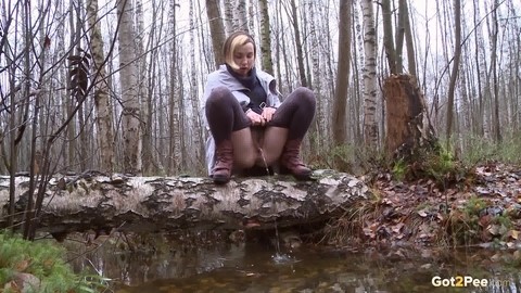 Clothed girl Anya pulls down tights on a log to pee into a stream in the woods | Фото 3