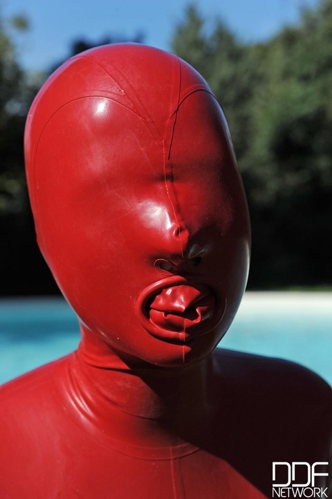 Kinky slut Sandy K poses & masturbates poolside fully covered by a latex suit