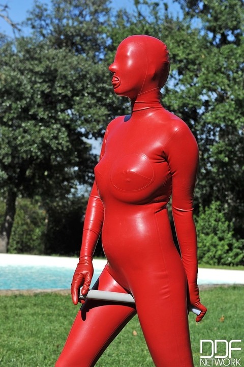 Kinky slut Sandy K poses & masturbates poolside fully covered by a latex suit | Фото 20