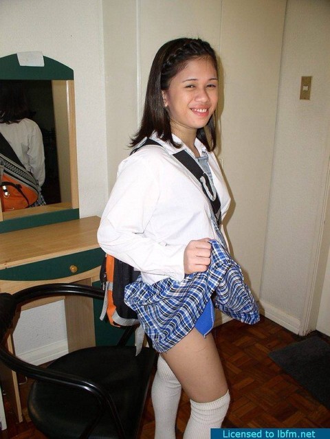 Young Asian girl removes her school uniform for her first nude poses