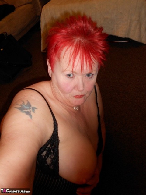 Older redhead Valgasmic Exposed exposes her breasts during self shot action