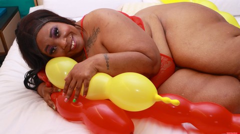 Ebony SSBBW Simone Thyke gets up close and personal with balloons on a bed