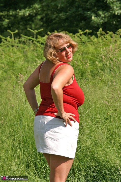 Fat mature lady Curvy Claire uncovers her large tits and big ass in a field | Фото 3