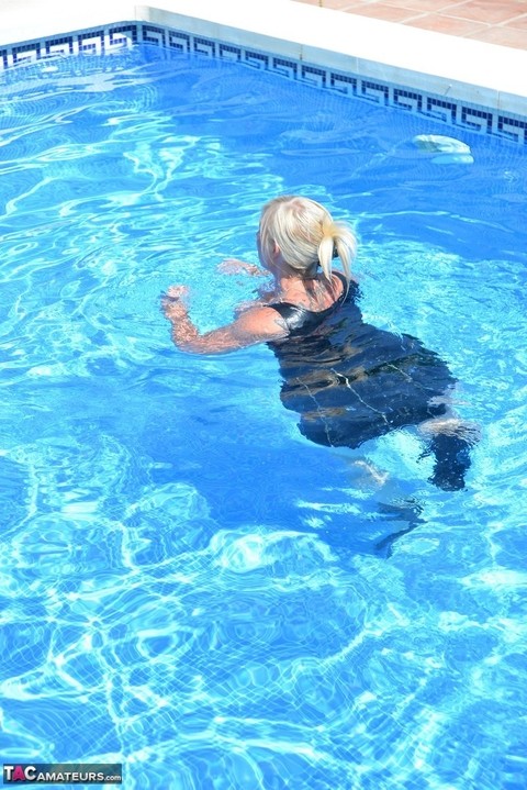 Thick blonde Melody displays her ample cleavage while fully clothed in a pool | Фото 8