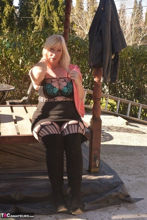 Overweight blonde Melody uncovers her brassiere on a patio in OTK boots | Фото 10