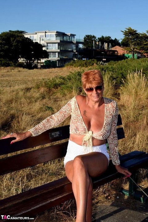 Mature redhead Dimonty exposes her sagging tits on a bench down by the sea | Фото 16