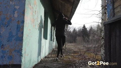 Solo girl pulls down black hose before squatting to pee beside a building | Фото 14