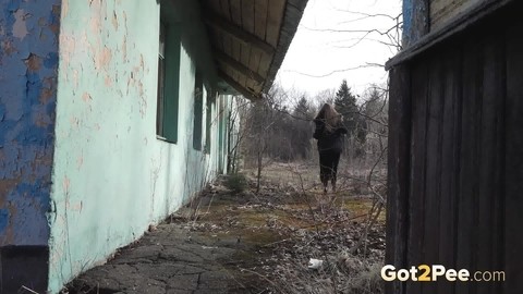 Solo girl pulls down black hose before squatting to pee beside a building | Фото 15