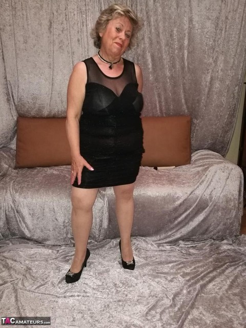 Horny granny Caro hikes up her dress to masturbate in nylons and heels | Фото 1