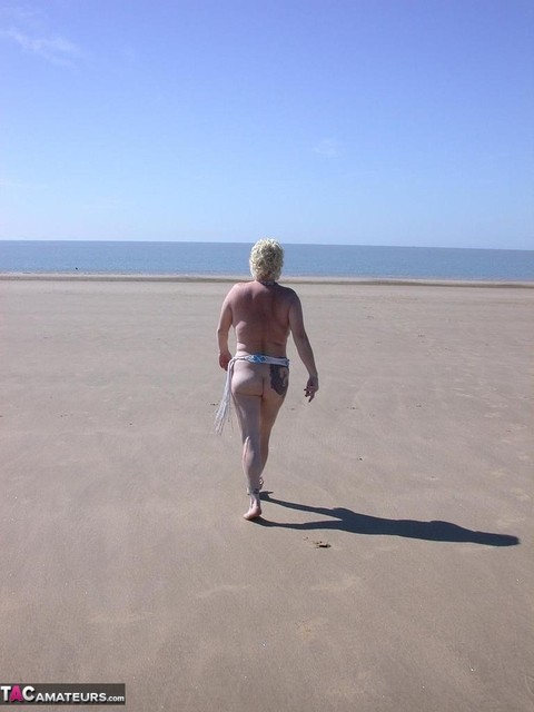 Older blonde amateur Mary Bitch takes a pee before going topless in the ocean | Фото 13