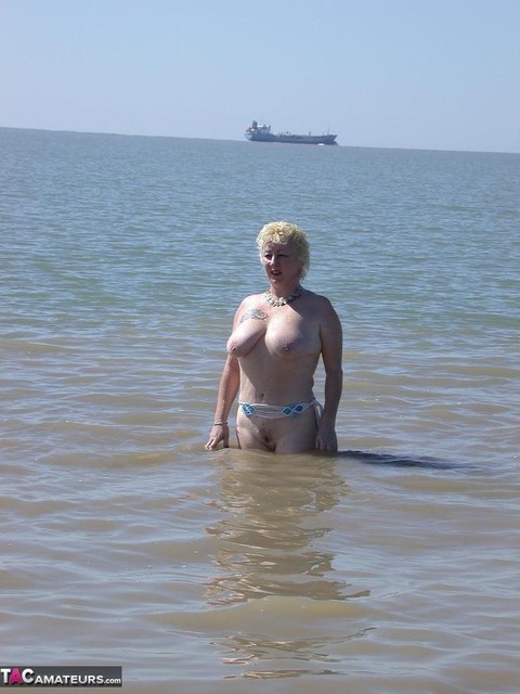 Older blonde amateur Mary Bitch takes a pee before going topless in the ocean | Фото 15