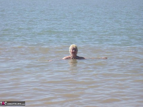 Older blonde amateur Mary Bitch takes a pee before going topless in the ocean | Фото 16