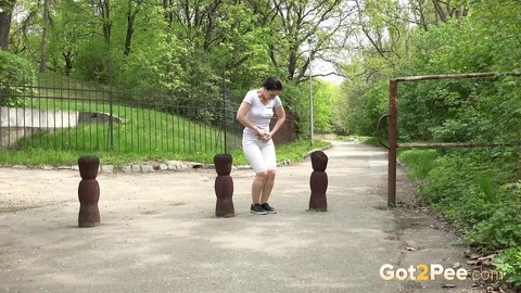 Dark-haired girl takes a piss on a public path in the middle of the day | Фото 1