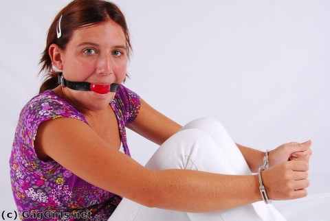 Clothed redhead fits herself with a ball gag while wearing handcuffs | Фото 12